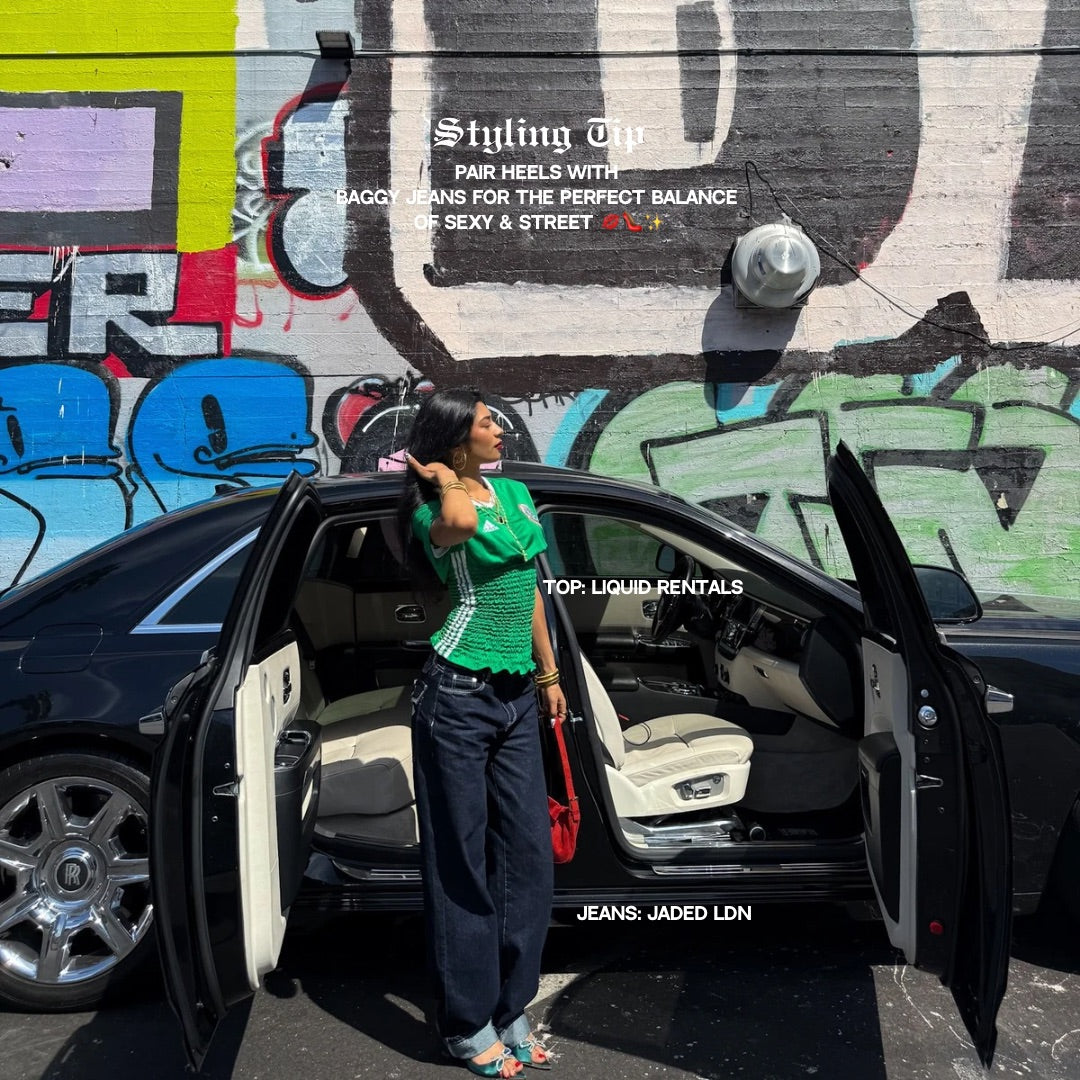 Woman standing next to an open car door with a colorful graffiti wall in the background