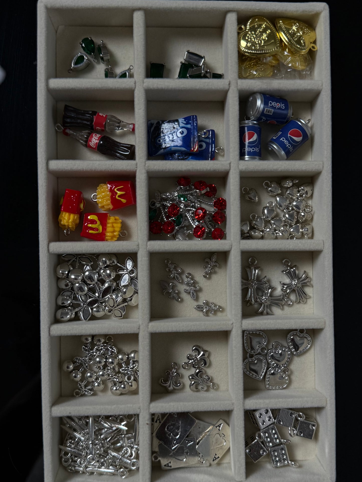 Collection of various small metal charms in a display case.