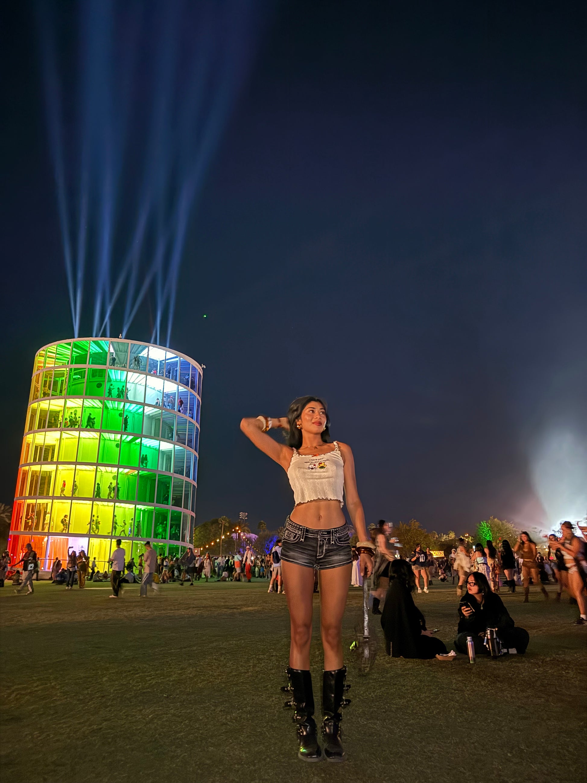 Person standing next to a colorful light sculpture at night