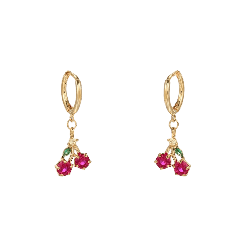 Gold earrings with red gemstones on a green background